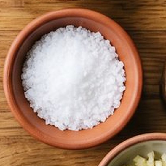 A pepper mill and salt on a wooden worktop