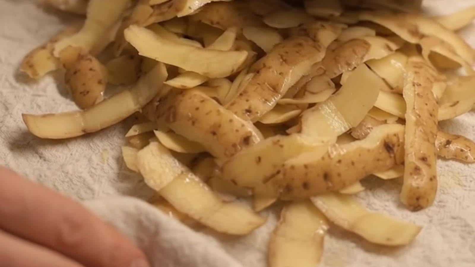 Potato peels drying on a white tea towel